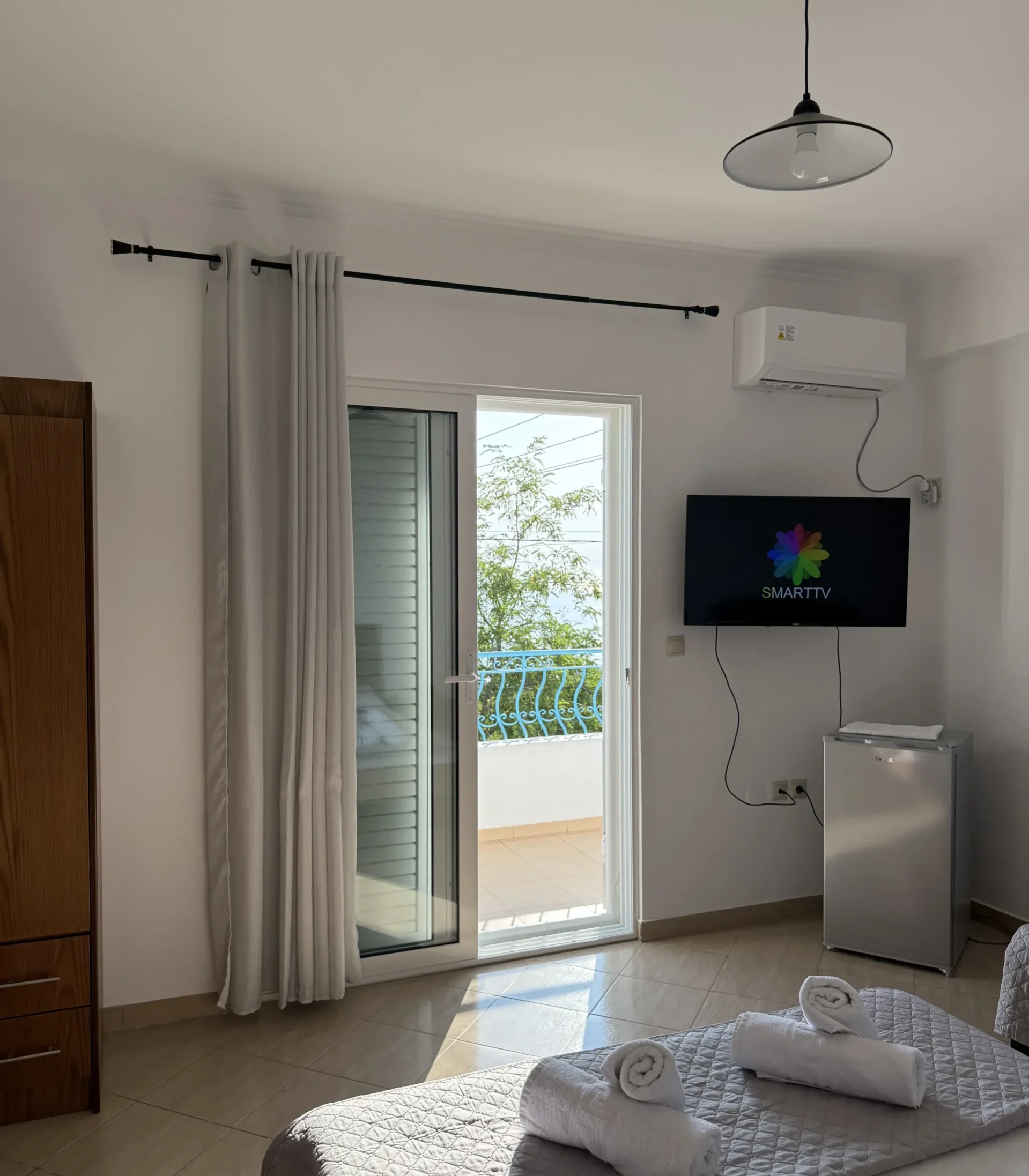 Triple room with a sea view balcony, double bed, and modern amenities at Kolagji Rooms in Lukovë.
