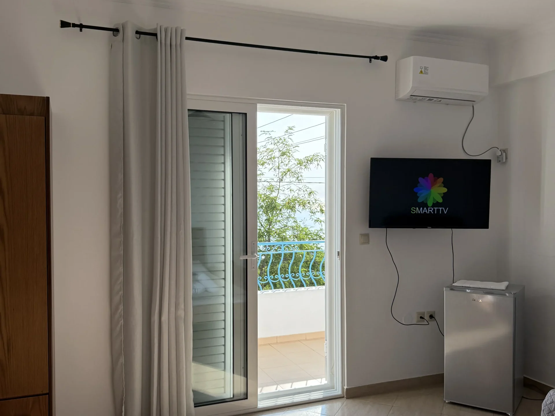 Triple room with a sea view balcony, double bed, and modern amenities at Kolagji Rooms in Lukovë.