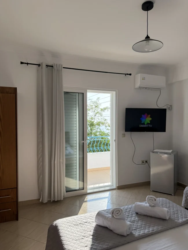 Triple room with a sea view balcony, double bed, and modern amenities at Kolagji Rooms in Lukovë.