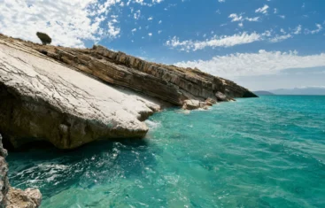 Home 4 Stunning white rock formations meeting the crystal-clear turquoise waters of Shpella Beach.