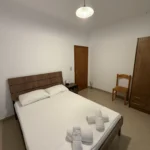 Comfortable double bed and wooden wardrobe in the Budget Double Room at Kolagji Rooms in Lukovë.