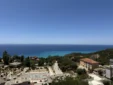 Wide panoramic daytime view of Lukovë village, coastal mountains, and the expansive Ionian Sea from our rooms.