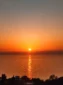 Bright orange evening sunset over the Albanian Riviera coastline, seen from the balcony at Kolagji Rooms.