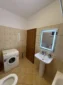 Convenient washing machine and lighted vanity mirror in the shared guest bathroom on the Albanian Riviera.