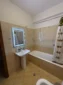 Modern sink, LED mirror, and full bathtub in the shared bathroom for our affordable accommodation.