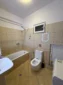 Spacious shared bathroom featuring a washing machine, bathtub, and fresh facilities in Lukovë.