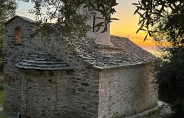 Home 5 Traditional stone architecture and slate roof of the Shën e Premte church during a beautiful Lukovë sunset.