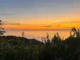 Vibrant orange and yellow sunset over the ocean horizon viewed from the hills of Lukovë, Albania.