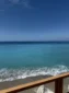 Turquoise waters of the Ionian Sea seen from a wooden viewing deck at Shpella Beach in Lukovë.