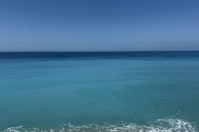 Turquoise waters of the Ionian Sea seen from a wooden viewing deck at Shpella Beach in Lukovë.