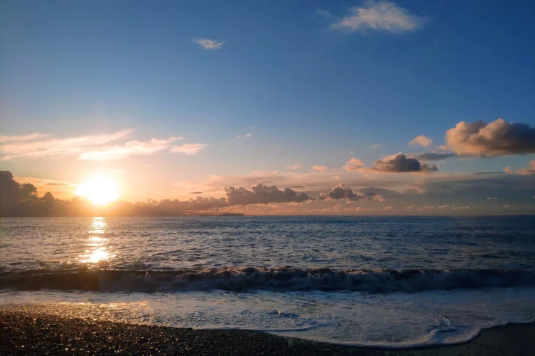 Sunset reflecting on the wet pebbles and gentle ocean waves at Shpella Beach in Lukovë.