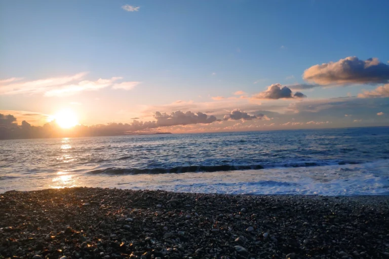 Peaceful evening sunset over the Ionian Sea viewed from the natural shoreline of Shpella Beach.