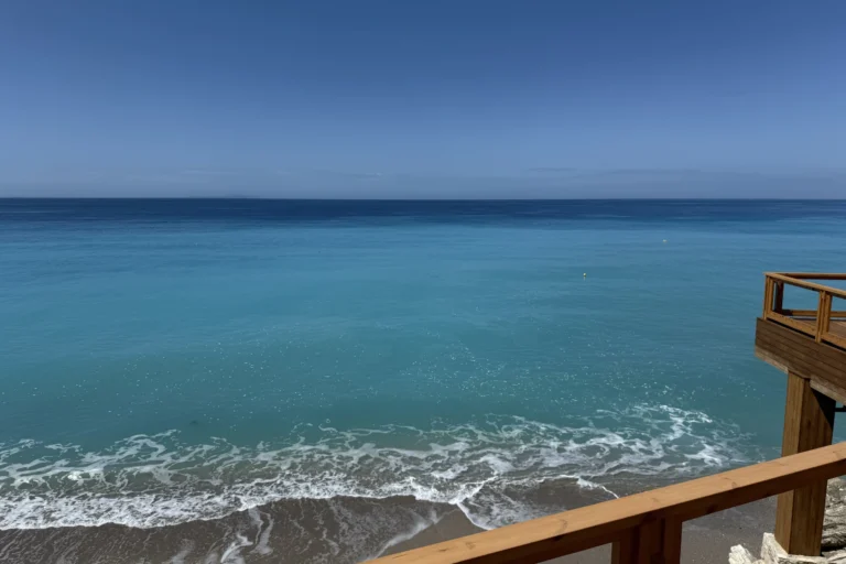 Wooden beachside deck overlooking the crystal clear blue waters of Shpella Beach on the Albanian Riviera.