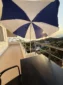 Private balcony with a sun umbrella and seating overlooking a beautiful sunset on the Albanian Riviera.