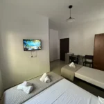 Comfortable double and single beds with a dining area in our affordable Lukovë triple room.