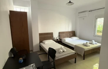 Home 2 Spacious triple room layout featuring beds, a dining table, and natural light from the outdoor view window.