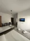 Spacious family room layout showing beds, a mini-fridge, and smart TV at Kolagji Rooms.