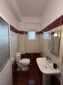 Modern private bathroom with a sink, mirror, and shower in the affordable triple room.