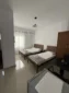 Comfortable beds and dining area inside the clean, budget-friendly triple room on the Albanian Riviera.