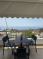 Balcony seating with black chairs and a table overlooking the Ionian Sea from the Lukovë triple room.