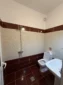 Modern en-suite bathroom with red tiles, a shower, and sink in the sea view triple accommodation.