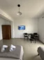 Indoor seating area and wall-mounted TV inside the comfortable sea view family room at Kolagji Rooms.