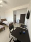 Room amenities including a mini-fridge, dining table, and TV in the spacious Lukovë triple accommodation.