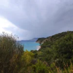 Elevated scenic view of the turquoise water and lush green coastline at beautiful Lumra Beach in Albania.