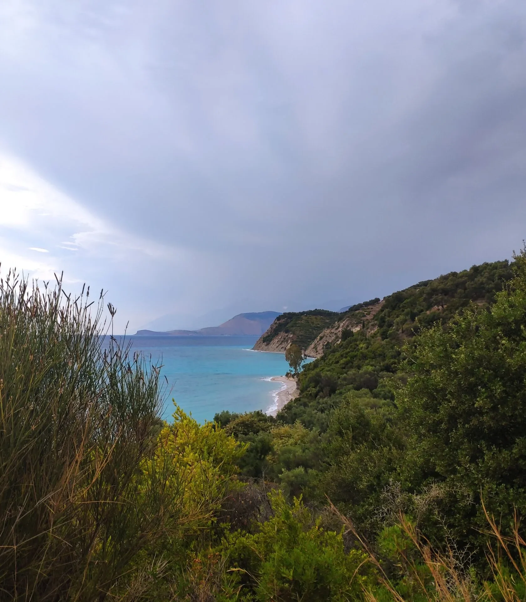 Elevated scenic view of the turquoise water and lush green coastline at beautiful Lumra Beach in Albania.