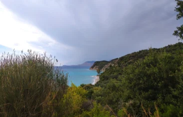 Home 6 Elevated scenic view of the turquoise water and lush green coastline at beautiful Lumra Beach in Albania.